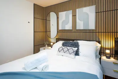 a bedroom with a large white bed with two mirrors at Quiet & Walkable - Stampede, BMO, Nightlife & Eats in Calgary
