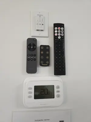 three remote controls sitting on top of an alarm clock at Shaganappi 2BR with private Baths, Walk to CTrain, Garage Parking, Full Kitchen in Calgary
