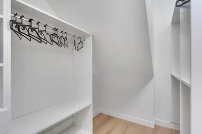 a room with white walls and a white shelf at Shaganappi 2BR with private Baths, Walk to CTrain, Garage Parking, Full Kitchen in Calgary