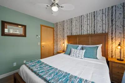 a bedroom with a large bed with blue walls at 2 Bedroom Condo Banff, Canmore sleeps 6 comfortably in Canmore