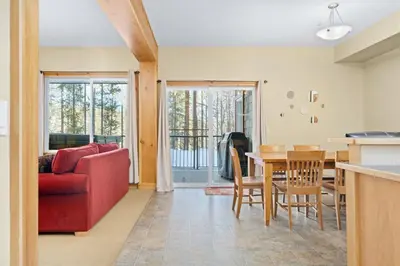 a living room with a red couch and a table at 2BR Kimberley Escape with Private Hot Tub and BBQ in Kimberley