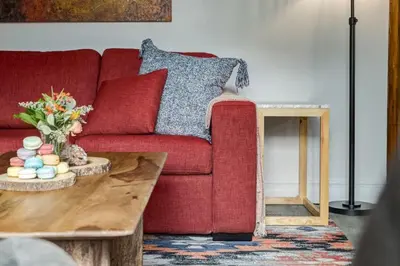 a living room with a red couch and a coffee table at Eagles Nest Chalet with Private Deck Near Banff in Canmore