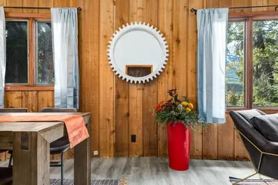a living room with a table and a mirror at Eagles Nest Chalet with Private Deck Near Banff in Canmore