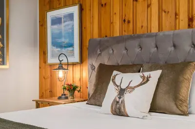 a bedroom with a bed with a deer pillow on it at 2BR Red Cedar Lodge near Banff with Mountain Views in Canmore