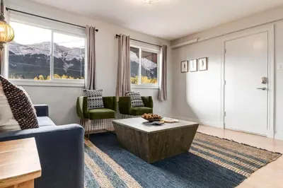 a living room with two chairs and a coffee table at 2BR Red Cedar Lodge near Banff with Mountain Views in Canmore