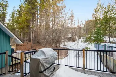 a balcony with snow on a fence and trees at 3BR Oasis Private Hot Tub and Sauna Walk to Ski Hill in Kimberley