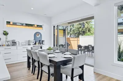 a kitchen and dining room with a table and chairs at Luxurious 4BR Beach Retreat with Backyard and Balcony in Penticton