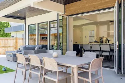 a patio with a white table and chairs at Luxurious 4BR Beach Retreat with Backyard and Balcony in Penticton