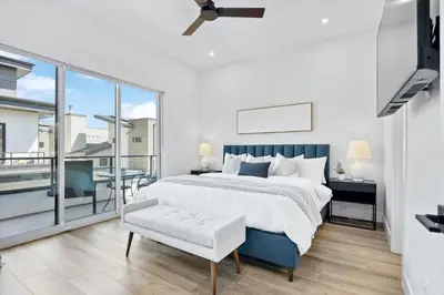 a bedroom with a large bed and a balcony at Luxurious 4BR Beach Retreat with Backyard and Balcony in Penticton