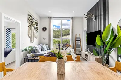 a living room with a dining room table and a couch at Luxe 3BR Golden Hideaway Top Floor, Balcony & BBQ in Golden