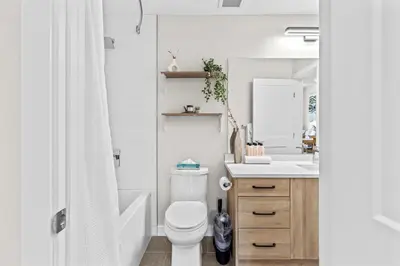 a bathroom with a white toilet and a sink at Luxe 3BR Golden Hideaway Top Floor, Balcony & BBQ in Golden