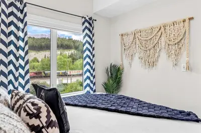 a bedroom with a bed and a window at Luxe 3BR Golden Hideaway Top Floor, Balcony & BBQ in Golden