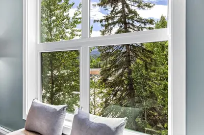 a window with a view of a tree at Scenic Riverstone 2BR w/ Balcony + BBQ, Sleeps 6! in Golden