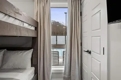 a bedroom with a bunk bed and a window at Brand New 3BR Rockies Haven w/ Balcony, Pool & Gym in Dead Man's Flats