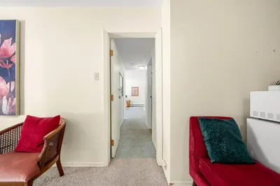a living room with a red couch and a hallway at Kimberley Escape: 1BR+Studio w/ Hot Tub, Pool, BBQ in Kimberley