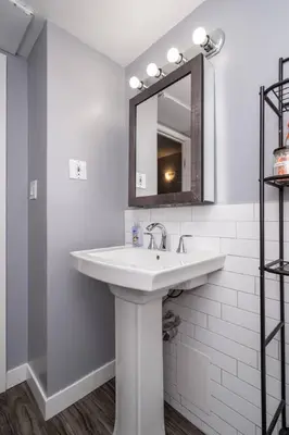 a white bathroom with a sink and a mirror at Stylish DT Condo ~2 Blocks from Stampede Grounds in Calgary