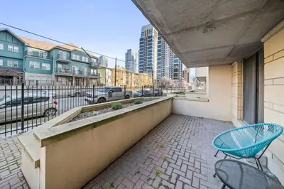 a balcony with a blue chair and a street at Stampede Modern downtown Condo Spacious 2BR in Calgary