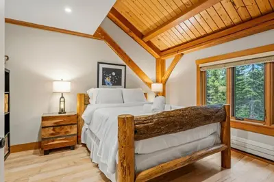 a bedroom with a large bed and a wooden ceiling at Highlands Homestead Luxury Retreat in Bragg Creek