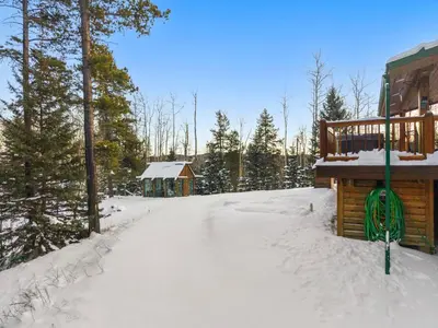 a log cabin in the snow with a gazebo at Highlands Homestead Luxury Retreat in Bragg Creek