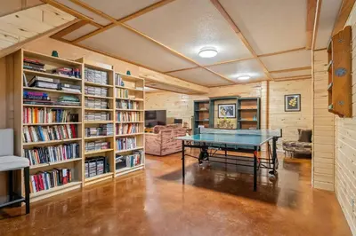 a room with a ping pong table in a library at Highlands Homestead Luxury Retreat in Bragg Creek