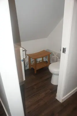 a bathroom with a toilet and a wooden table at Nesting Ravens cottage in Nanaimo