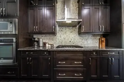 a kitchen with wooden cabinets and a stove top oven at Luxury Sleeps 10 King bed Jacuzzi 10 Min to West Edmonton Mall in Edmonton