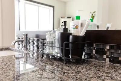 a bathroom counter with a tray with items on it at Luxury Sleeps 10 King bed Jacuzzi 10 Min to West Edmonton Mall in Edmonton