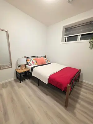 a bedroom with a bed with a red blanket at Amaville Suites - One Bedroom in West Edmonton in Edmonton