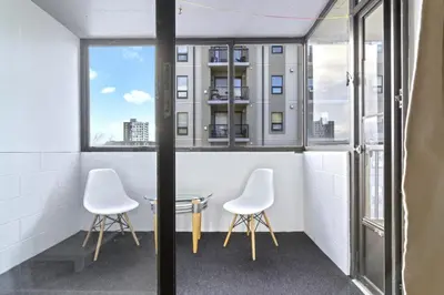 two chairs and a table in a room with windows at Bright 2 Bedroom Suite at Victoria & Stampede Park in Calgary