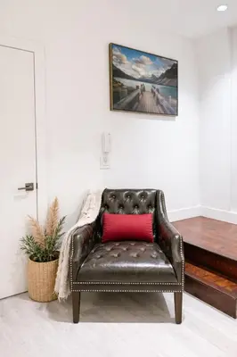 a leather couch with a red pillow in a room at Cozy Deep Cove Retreat Near Quarry Rock Hike in North Vancouver