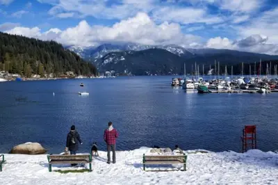 a group of people standing in the snow near a marina at Cozy Deep Cove Retreat Near Quarry Rock Hike in North Vancouver