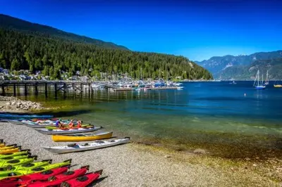 a group of kayaks sitting on the shore of a lake at Cozy Deep Cove Retreat Near Quarry Rock Hike in North Vancouver