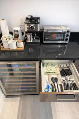 a kitchen with a black counter top with a coffee maker at Cozy Deep Cove Retreat Near Quarry Rock Hike in North Vancouver