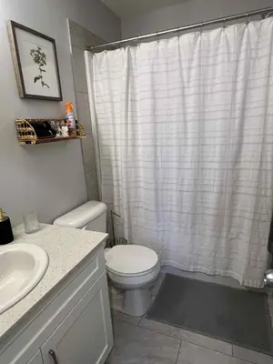 a bathroom with a toilet and a shower curtain at Northside Dream Home in Edmonton