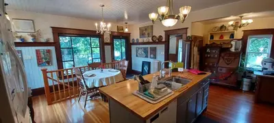 a kitchen with a sink and a table in a room at Rosewood in New Westminster