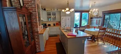 a kitchen with white cabinets and a brick wall at Rosewood in New Westminster