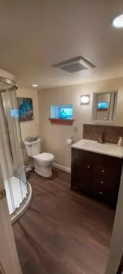 a bathroom with a toilet and a sink and a shower at Rosewood Garden Studio in New Westminster
