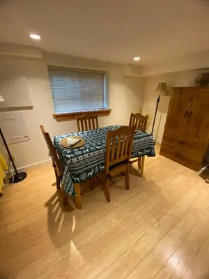 a dining room table and chairs in a room at Rosewood Garden Studio in New Westminster
