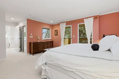 a bedroom with a large white bed and orange walls at Entire Spanish Style Villa 5 Bedrooms near Ocean in West Vancouver