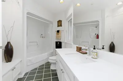 a white bathroom with two sinks and a toilet at Entire Spanish Style Villa 5 Bedrooms near Ocean in West Vancouver