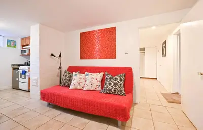 a red couch with pillows in a living room at Basement Suite in South Vancouver in Vancouver