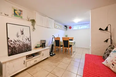 a living room with a tv and a table at Basement Suite in South Vancouver in Vancouver