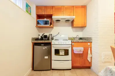 a small kitchen with a stove and a microwave at Basement Suite in South Vancouver in Vancouver