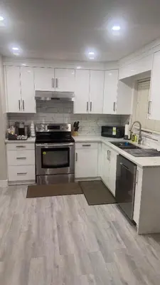 an empty kitchen with white cabinets and an oven at J & J Dream Villa Ltd in Abbotsford