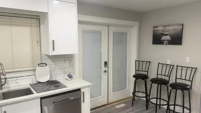 a kitchen with three bar stools and a counter top at J & J Dream Villa Ltd in Abbotsford