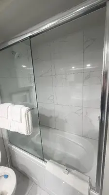 a bathroom with a glass shower and a toilet at J & J Dream Villa Ltd in Abbotsford