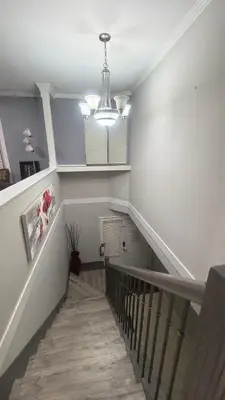 a hallway with a staircase with a chandelier at J & J Dream Villa Ltd in Abbotsford