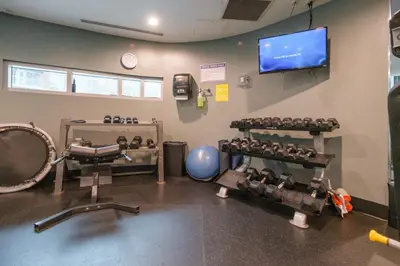 a gym with several sets of equipment in a room at Cozy Condo in Prime Location with Jacuzzi Pool & Sauna in Vancouver