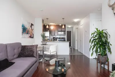 a living room with a couch and a table at Cozy Condo in Prime Location with Jacuzzi Pool & Sauna in Vancouver