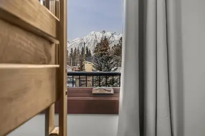 a view of a snowy mountain from a window at Heart of Canmore Condo managed by Little Sister Getaways in Canmore